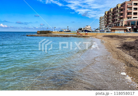View of the promenade in Marsalforn Bay (Salt Pans) at Gozo, Malta at sunny day with some clouds View of the promenade in Marsalforn Bay (Salt Pans) at Gozo, Malta at sunny day with some clouds 118058017