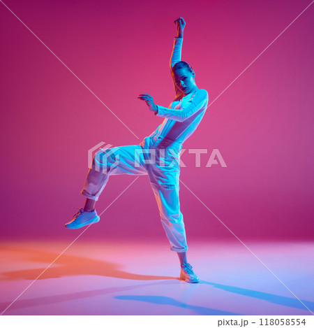 Display of rhythm and style. Young talented girl, dance in motion, training, performing hip-hop against pink background in neon light Display of rhythm and style. Young talented girl, dance in motion, training, performing hip-hop against pink background in neon light 118058554
