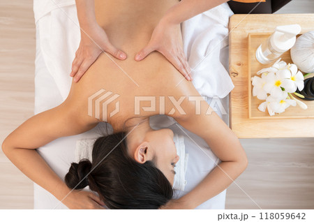 Hands of masseur massaging back of relaxed woman with aromatherapy essential oil on massage table. Hands of masseur massaging back of relaxed woman with aromatherapy essential oil on massage table. 118059642