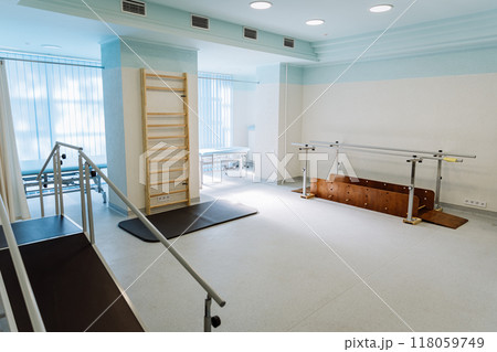 Rehabilitation room with parallel bars and equipment for physical therapy and mobility training Rehabilitation room with parallel bars and equipment for physical therapy and mobility training 118059749