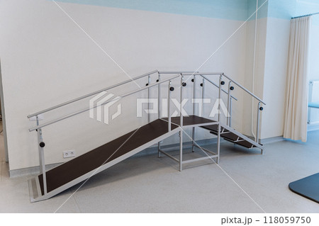 Rehabilitation room with parallel bars and equipment for physical therapy and mobility training 118059750