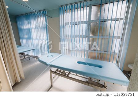 Physiotherapy room with massage tables and bright windows for a calm and comfortable therapy session 118059751