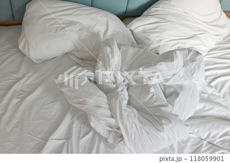 Messy hotel bed closeup 118059901