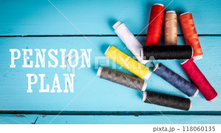 Pension Plan. Text and colorful spools of thread on a blue wooden background 118060135