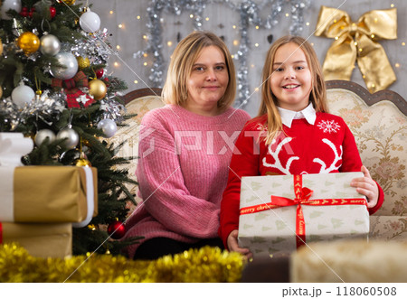 Mom and daughter holding gift in Christmas interior 118060508