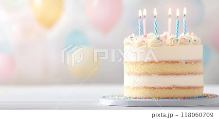Birthday vanilla cake adorned with colorful candles 118060709