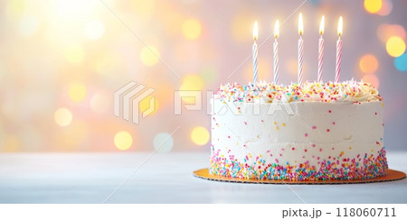 Colorful birthday cake adorned with candles and sprinkles 118060711
