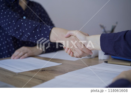 Accountants or auditors shaking hands after reviewing financial documents in office. Audit and taxes, handshake as a symbol of agreement Accountants or auditors shaking hands after reviewing financial documents in office. Audit and taxes, handshake as a symbol of agreement 118061608