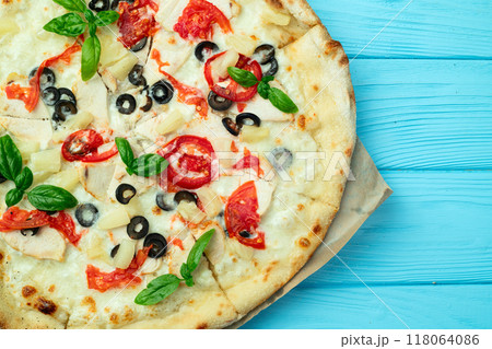Pizza with mozzarella cheese , olives , chicken , pineapple , basil and tomatoes 118064086