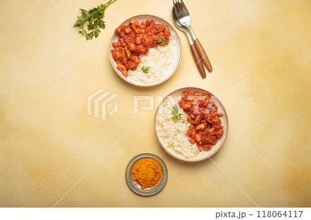 Indian chicken curry with rice and turmeric on yellow background with copy space top view Indian chicken curry with rice and turmeric on yellow background with copy space top view 118064117