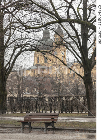Bench made wood and iron stand in the garden of the Munich Residenz with St.Cajetan and Adelaide in the background. 118064825
