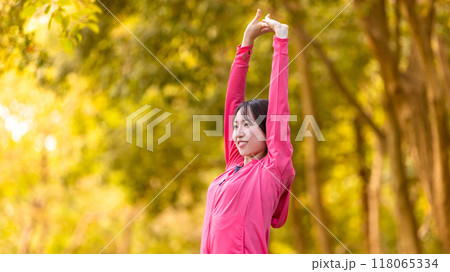 スポーツの秋・紅葉の中でストレッチをする若い女性 118065334