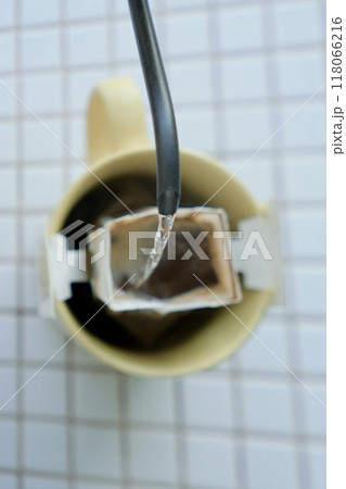 yellow cup freshly brewed coffee with convenient drip filter on table. prepare freshly brewed coffee 118066216