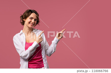 Recommending smiling woman pointing at right side, copy space or advertising. 118066766