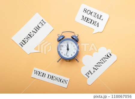 A blue alarm clock sits on a table with a bunch of paper cutouts around it A blue alarm clock sits on a table with a bunch of paper cutouts around it 118067056