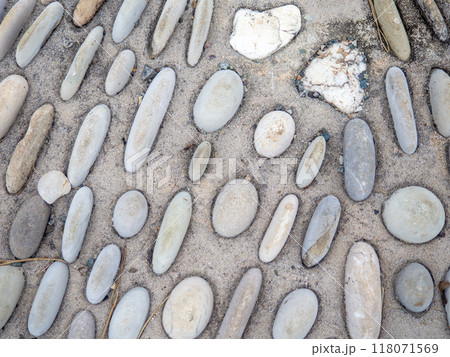 Pattern of sea stones in cement. Ground cover in the park. Background with bumps. Background of beach pebbles and concrete. 118071569