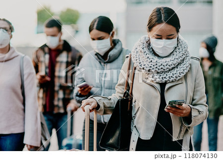 Home is never far away with wireless technology. Shot of a young woman using a smartphone and wearing a mask while travelling in a foreign city. 118074130