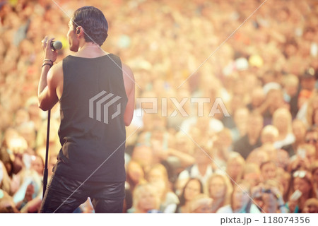 Singer, microphone and concert with man at festival for rock, performance and party in nature. Celebration, energy and audience with male musician on stage for club, rave and show event in outdoors Singer, microphone and concert with man at festival for rock, performance and party in nature. Celebration, energy and audience with male musician on stage for club, rave and show event in outdoors 118074356