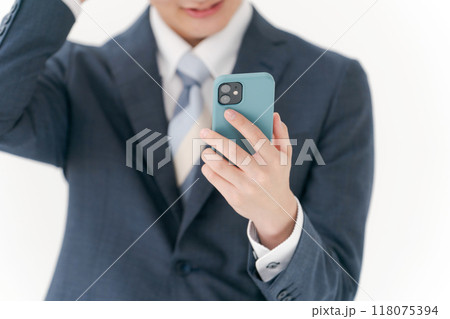 スマホを見て悩むビジネスマン 118075394