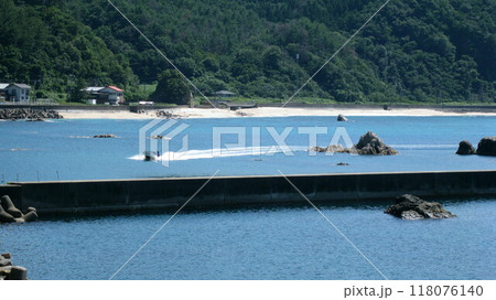 漁港へ向かう漁船と青い海と緑の山と白い砂浜 118076140