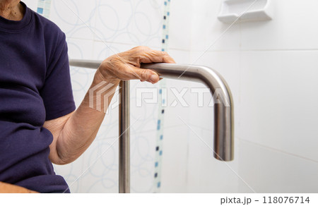 Elderly Woman Gripping Bathroom Safety Rail 118076714
