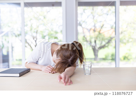 テーブルでうなだれる女性 118076727
