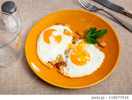 Appetizing breakfast with scrambled eggs and juicy bacon closeup 118077816