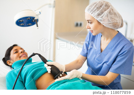 Doctor making rejuvenation electroporation procedure on abdomen Doctor making rejuvenation electroporation procedure on abdomen 118077859