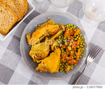 Hearty homemade lunch - few pieces of stewed chicken and green peas with carrots 118077860
