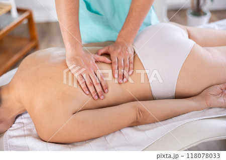 Close up male manual worker doing spa massage to young girl in room Close up male manual worker doing spa massage to young girl in room 118078033