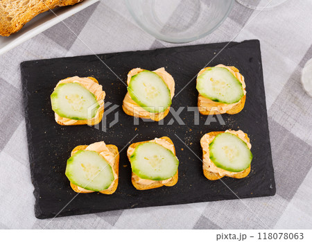 Simple homemade snack of sandwiches, greased with butter and decorated with slice of cucumber Simple homemade snack of sandwiches, greased with butter and decorated with slice of cucumber 118078063