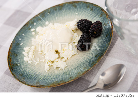 Serving of cottage cheese topped with cream and blackberries Serving of cottage cheese topped with cream and blackberries 118078358