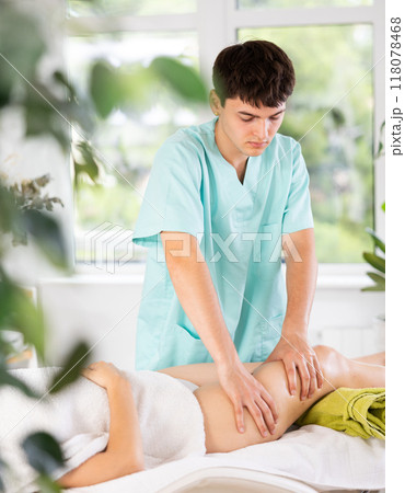 Young guy massages thighs of adult woman 118078468