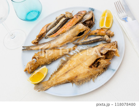 On white background, there is plate with fried fish of different varieties 118078480