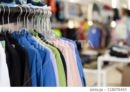 Sweatshirts hung on rack in clothing store 118078483