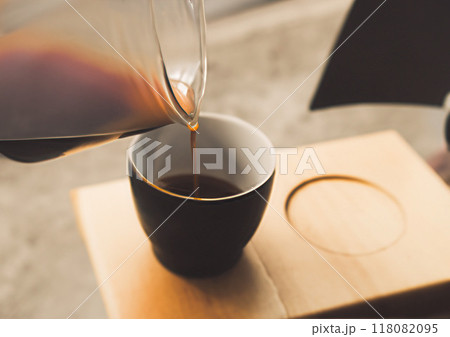 フォトバッシュ　ガラス容器から注がれる木製トレーに乗ったコーヒー　 118082095