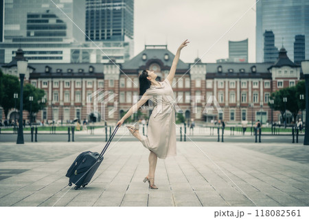キャリーバッグをひいて旅にでた、若い女性心弾む様子 118082561