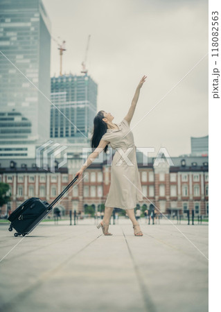 キャリーバッグをひいて旅にでた、若い女性心弾む様子 キャリーバッグをひいて旅にでた、若い女性心弾む様子 118082563