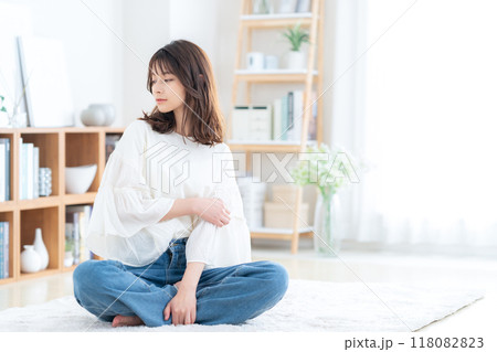 リビングで座ってくつろぐ若い女性 118082823