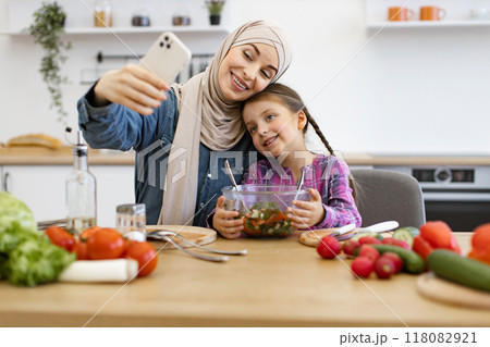 Muslim mother and daughter taking selfie with healthy salad in kitchen 118082921