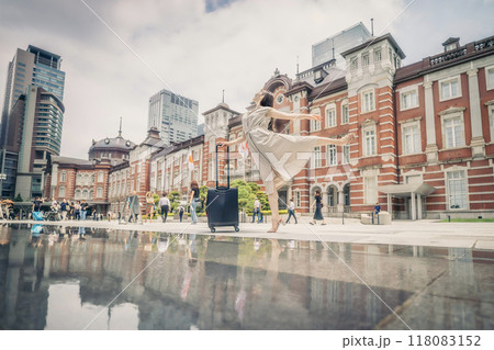 キャリーバッグをひいて旅にでた、若い女性の心弾む様子 118083152