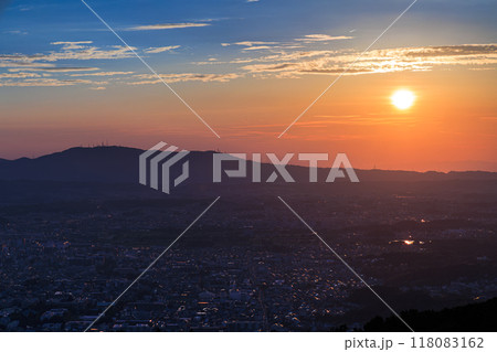 奈良若草山初秋の夕景　奈良の街を夕焼け色に染めながら生駒山ろくに沈んでいく夕日 118083162