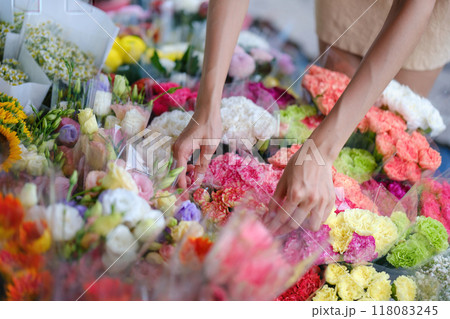A woman is picking out flowers at a flower market 118083245
