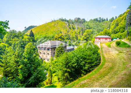 The Spalov Hydroelectric Power Plant is surrounded by lush greenery and rolling hills in Czechia, showcasing its integration into the natural landscape 118084318