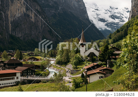 Tranquil Swiss village with mountain views, historic church, perfect for a peaceful vacation in the alpine countryside Tranquil Swiss village with mountain views, historic church, perfect for a peaceful vacation in the alpine countryside 118084628