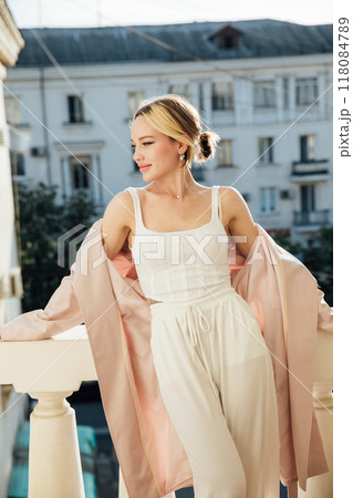 Beautiful fashionable slim blonde woman sitting on a chair Beautiful fashionable slim blonde woman sitting on a chair 118084789