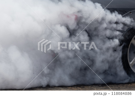 White smoke from tire, Car burnout wheels tire with white smoke,Car wheel burnout with smoke from the spinning tyre, Drag car wheel burns tires preparation for the race. 118084886