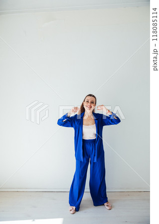 Beautiful woman in blue summer suit in white room Beautiful woman in blue summer suit in white room 118085114