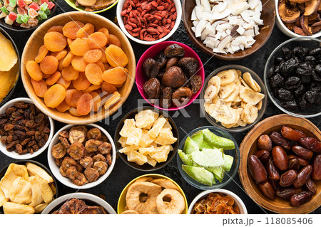Assorted organic healthy dried sweet berries and fruits snack in various bowl plates on black  118085406