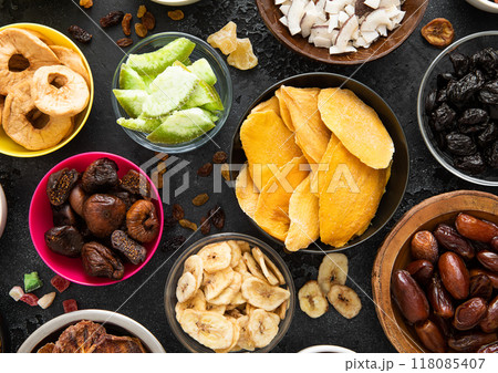 Assorted organic healthy dried sweet berries and fruits snack in various bowl plates on black  118085407